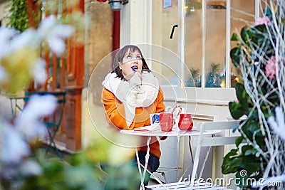 Cheerful young girl in Parisian outdoor cafe Stock Photo