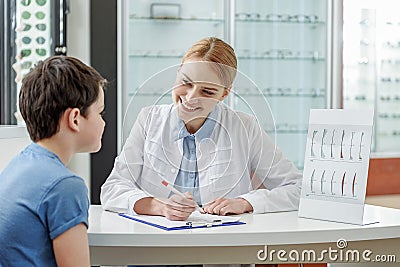 Cheerful young oculist talking to small boy Stock Photo