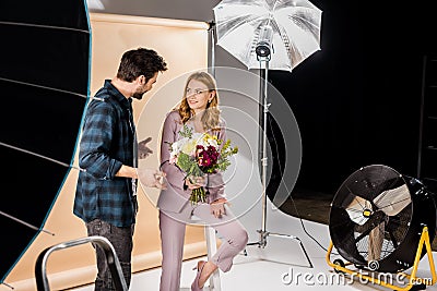 cheerful young photographer and beautiful female model talking Stock Photo