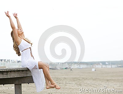 Cheerful young woman with arms raised Stock Photo