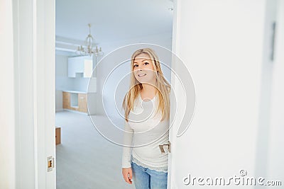 Cheerful young woman inviting people to enter in home. Stock Photo