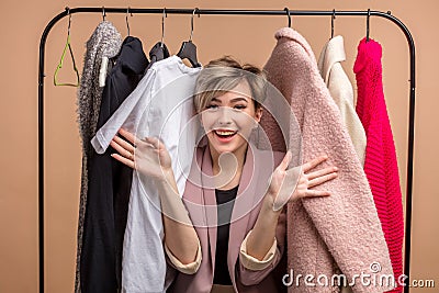 Cheerful young woman is looking through the outfit Stock Photo