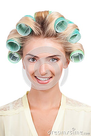 Cheerful young woman with rollers in her head Stock Photo