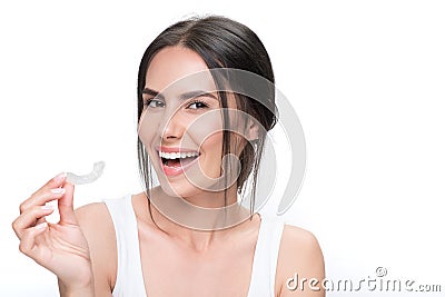 Cheerful young woman showing clear aligner Stock Photo