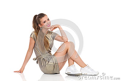 Cheerful Young Woman Sitting On A Floor Stock Photo