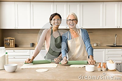 Cheerful younger and elder baker women cooking homemade bakery food Stock Photo