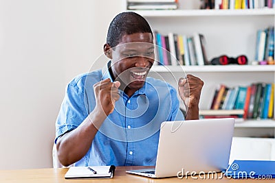 Cheering african american businessman with computer Stock Photo