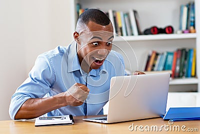 Cheering african american man at computer Stock Photo