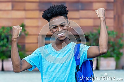 Cheering afro american freshman showing with backpack Stock Photo