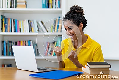 Cheering brazilian female student learning at computer Stock Photo