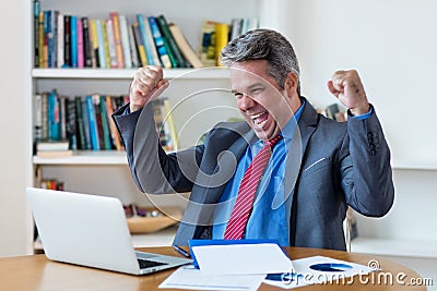 Cheering mature businessman making money with online business Stock Photo
