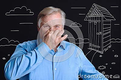 Cheerless senior man putting his hand to the nose Stock Photo