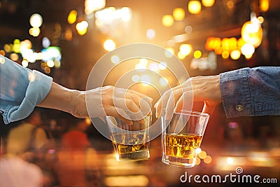 Cheers clinking of friends with bourbon whisky drink in party Stock Photo