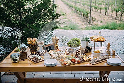 Cheese bar of several kinds of cheese, snacks, honey, nuts decorated on wooden table at the wedding party. Concept of Stock Photo