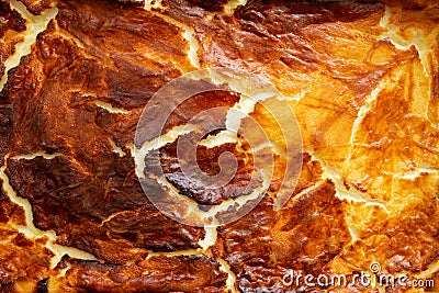 Cheese cake crust, burned and cracked, golden brown abstract texture, close up Stock Photo