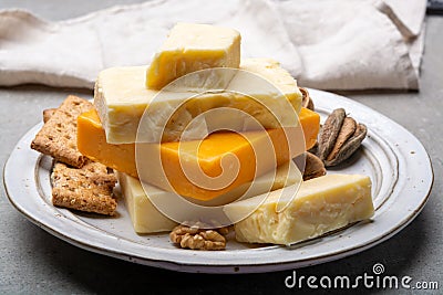 Cheese collection, matured and orange original British cheddar cheese in blocks served with crackers Stock Photo
