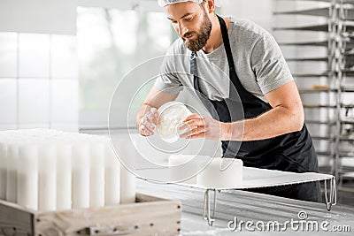 Cheese maker at the manufacturing Stock Photo