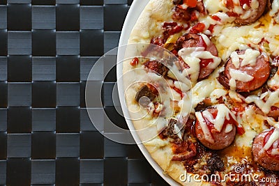 Close up of freshly home made pizza on a white plate with cheese, meat, onions, spicy products. Italian traditional food Stock Photo