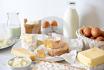 Cheese, milk, dairy products and eggs on rustic white wood background. Stock Photo