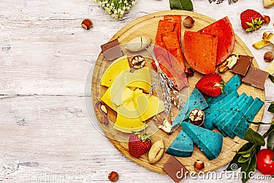 Cheese plate. Assorted multicolored hard Dutch cheeses. Blue and red pesto, aged gouda Stock Photo