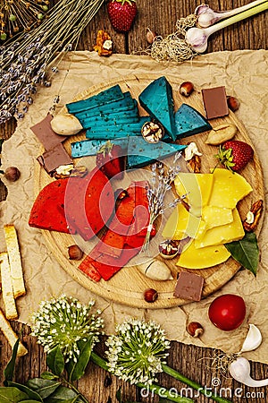 Cheese plate. Assorted multicolored hard Dutch cheeses. Blue and red pesto, aged gouda Stock Photo