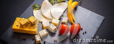 Cheese plate with blue cheese, brie, truffle hard cheese with grapes, figs, pears, honey, crackers, dried fruits and nuts on table Stock Photo