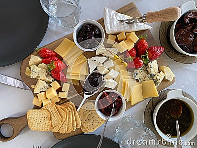 cheese plateCheese plate with camembert, brie, dor blue, strawberries, sun-dried tomatoes, olives on a wooden table, top Stock Photo