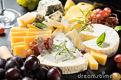 Cheese platter with craft cheese assortment on slate board. Stock Photo