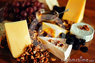 Cheese platter with different cheeses, grapes, nuts, honey, brea Stock Photo