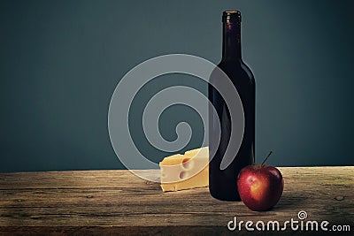 Cheese platter garnished with honey, apple and bottle of wine on rustic wooden board Stock Photo