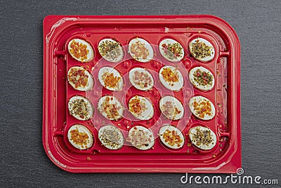 cheese platter. Mazzarella cheese with different spices. Cheese snacks of different taste in a plastic container or tray Stock Photo