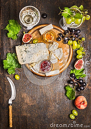 Cheese snack Gorgonzola and Camembert with wine glass honey knife cheese grapes on a branch with leaves Peaches on wooden rustic Stock Photo
