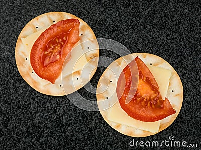 Cheese and Tomato on Water Biscuit Crackers Stock Photo