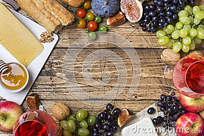 Cheese, wine, baguette grapes figs honey and snacks on the rustic wooden table top with copy space. Stock Photo