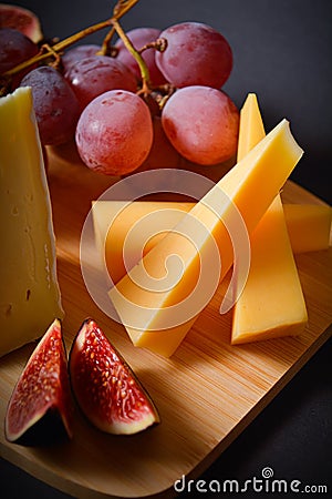Cheeseboard with Hard and soft French cheese pieces, grape and fig cuts Stock Photo