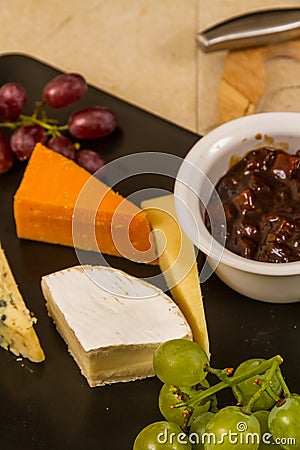 Cheeseboard platter with grapes and pickle and crackers Stock Photo