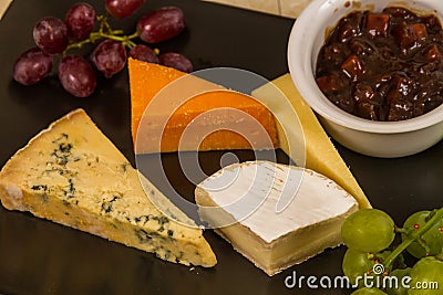 Cheeseboard platter with grapes and pickle Stock Photo