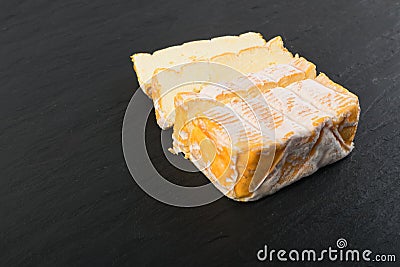 Cheeseboard with Sliced Yellow Cheese Close Up Stock Photo