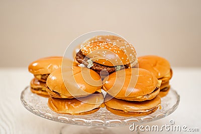 cheeseburgers on a round glass dish. fast food. original cake. Stock Photo