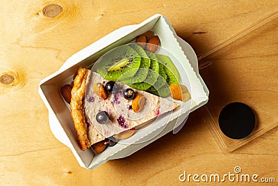 Cheesecake with blueberries, almond, raisins and sliced kiwi Stock Photo