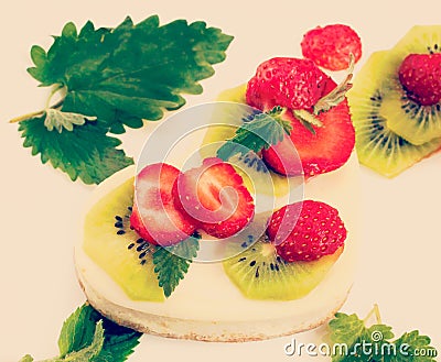 Cheesecake with fresh fruits, insta-retro effect, close-up Stock Photo