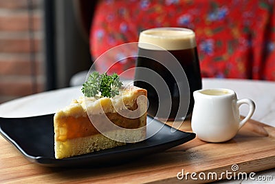 Cheesecake and iced coffee for afternoon snack on wooden plate. Stock Photo
