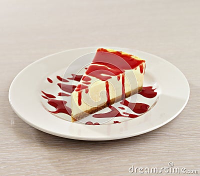 Cheesecake with strawberry syrup on white plate Stock Photo