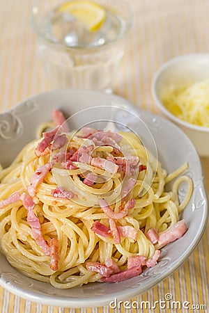 Cheesy pasta spaghetti with cheese and cream served with fried bacon Stock Photo