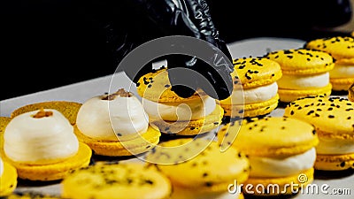 Chef is assembling yellow macarons, close-up. Stock Photo