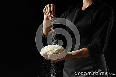 Chef, baker prepares bread. Flour freezing flour in the air. Advertising photo, on a black background, for design. Horizontal Stock Photo