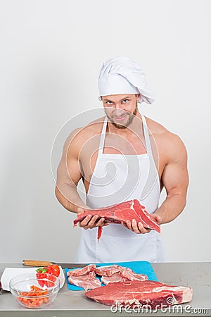 Chef bodybuilder preparing large chunks of raw meat. natural proteins Stock Photo