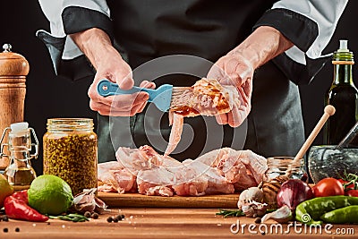 Chef brushing chicken wings with marinade sauce Stock Photo