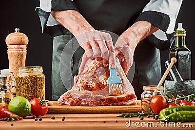 Chef brushing raw meat with marinade. Glazed pork ribs Stock Photo