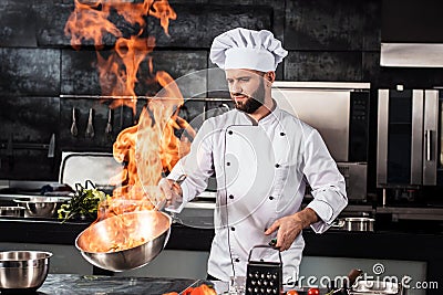 Chef cook food with fire at kitchen restaurant. Cook with wok at kitchen. Stock Photo